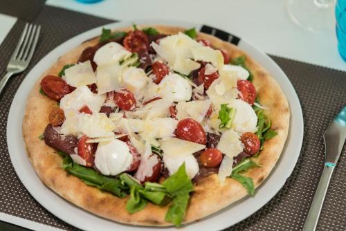 a pizza sitting on a plate on a table at Sicilia's Art Hotel & Spa in Acitrezza
