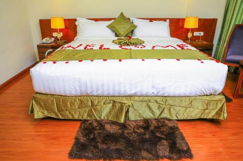 a large bed in a hotel room with a bedskirtspectspectspects at Denver boutique hotel in Addis Ababa