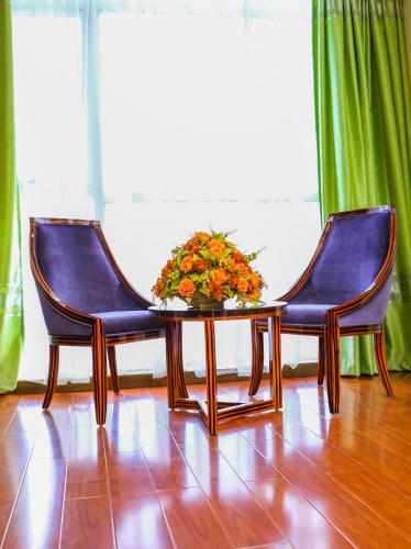 two chairs and a table with a vase of flowers at Denver boutique hotel in Addis Ababa
