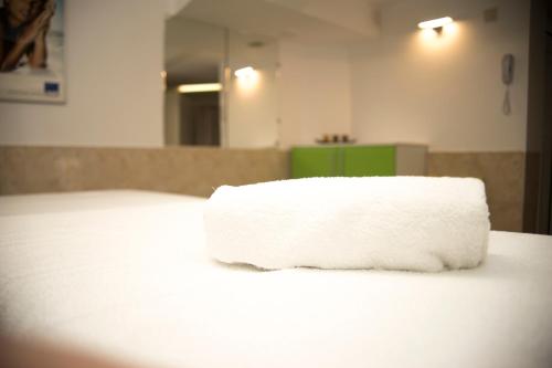 a roll of white towels sitting on top of a bed at Noviz Hotel in Plovdiv