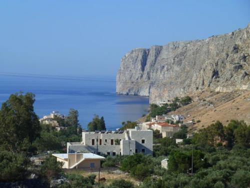a group of buildings on a hill next to the ocean at Akroyiali Apartments in Gerolimenas
