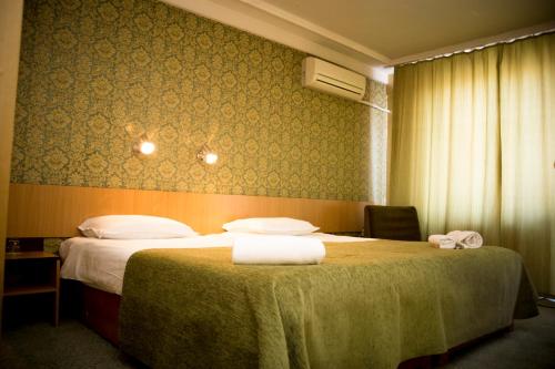 a hotel room with a bed with two towels on it at Noviz Hotel in Plovdiv