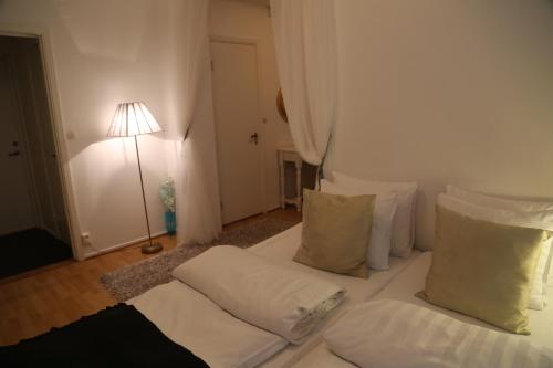 a bedroom with a bed with white sheets and pillows at Vingåker Hotell in Vingåker