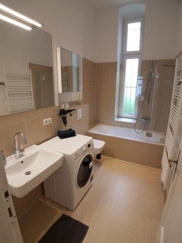 a bathroom with a sink and a washing machine at Apartment LANGEN - Cozy Family & Business Flair welcomes you - Rockchair Apartments in Berlin