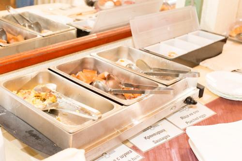 a buffet with several trays of food on a table at Noviz Hotel in Plovdiv