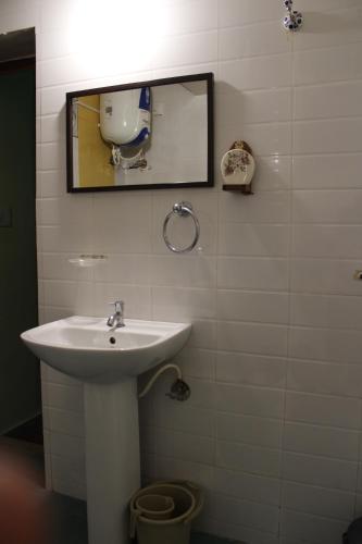 a bathroom with a sink and a mirror at Cornwall Coorg in Madikeri