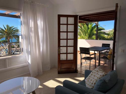 a living room with a couch and a table and a balcony at Apartamento Tabaybas in Puerto del Carmen