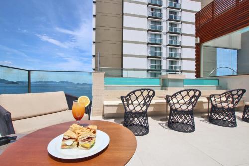 a table with a plate of food on a balcony at Ritz Copacabana Boutique Hotel in Rio de Janeiro