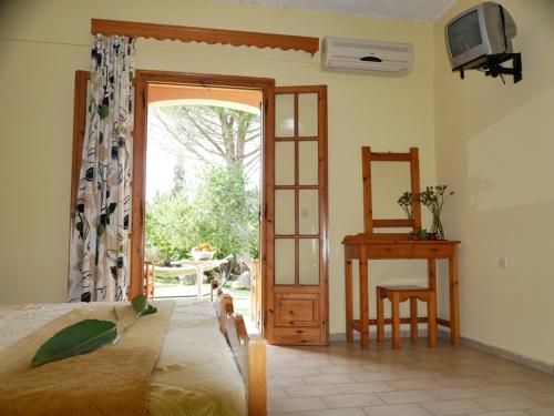 a bedroom with a bed and a sliding glass door at Marios Studios in Sidari