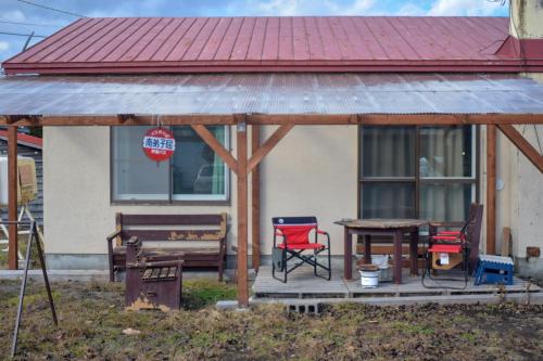 a gazebo with chairs and a table in front of a house at Shoei backpackes hostel in Teshikaga