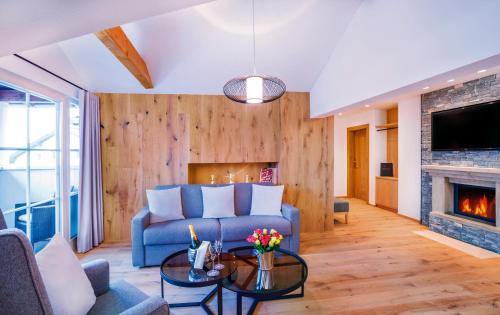 a living room with a blue couch and a fireplace at Das Reisch in Kitzbühel
