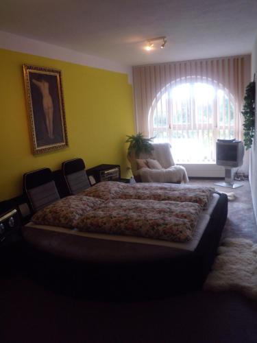 a bedroom with a bed and a couch and a window at Penzion U Urbanů in Němčice