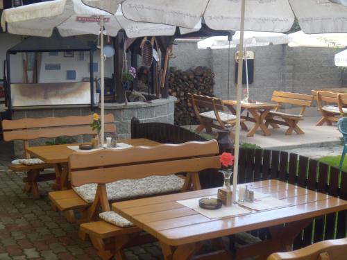 a restaurant with wooden tables and umbrellas at Penzion U Urbanů in Němčice