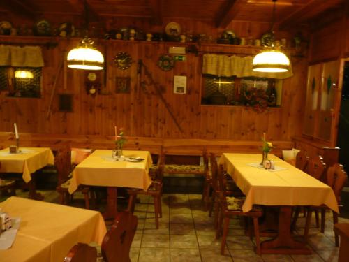 a restaurant with two tables and chairs with yellow table cloth at Penzion U Urbanů in Němčice