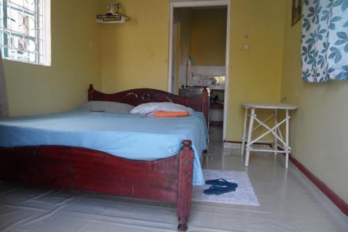 1 dormitorio con cama de madera en una habitación en Private Guest Wing, en Mombasa