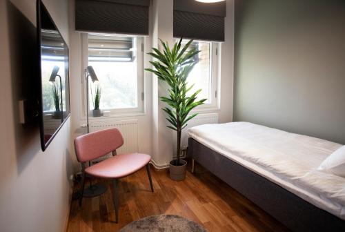 a bedroom with a bed and a potted plant at First Hotel The Studio in Stockholm