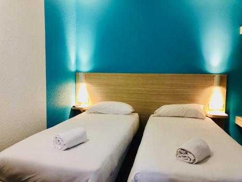 two beds sitting next to each other in a room at Hôtel du stade ex Kyriad Direct Lille Est Stade Pierre Mauroy in Villeneuve d'Ascq
