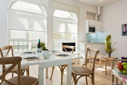 kuchnia i jadalnia ze stołem i krzesłami w obiekcie Suites Sevilla Plaza w Sewilli
