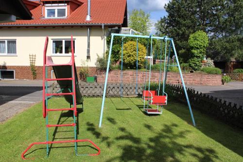 a playground with a ladder and a swing at Blumenschein-Ferienwohnung Unne in Kirchzell