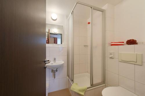 a bathroom with a shower and a toilet and a sink at meinHotel in Hamburg
