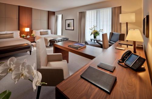 a hotel room with a desk and a hotel suite at The Langham, New York, Fifth Avenue in New York