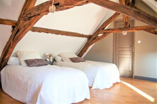 two beds in a attic bedroom with wooden beams at La Chapelle du Chateau Lagarrigue in Strenquels