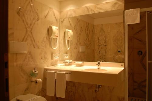 y baño con lavabo, espejo y aseo. en Hotel Vecchio Mulino, en Monopoli