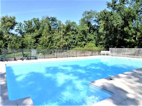 une grande piscine avec de l'eau bleue dans une cour dans l'établissement La Chapelle du Chateau Lagarrigue, à Strenquels