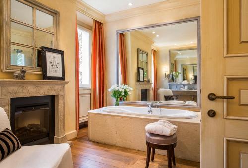 a large bathroom with a tub and a fireplace at L'Andana Tenuta La Badiola in Castiglione della Pescaia
