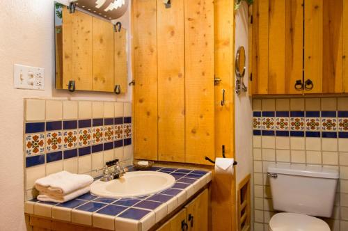 La salle de bains est pourvue d'un lavabo, de toilettes et de placards en bois. dans l'établissement Denton Cabin, à Taos Ski Valley