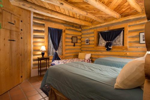 - une chambre avec 2 lits dans une cabane en rondins dans l'établissement Denton Cabin, à Taos Ski Valley