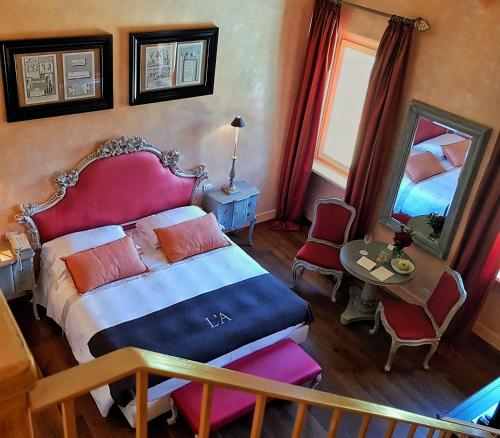 a bedroom with a bed and a table and a mirror at L'Andana Tenuta La Badiola in Castiglione della Pescaia