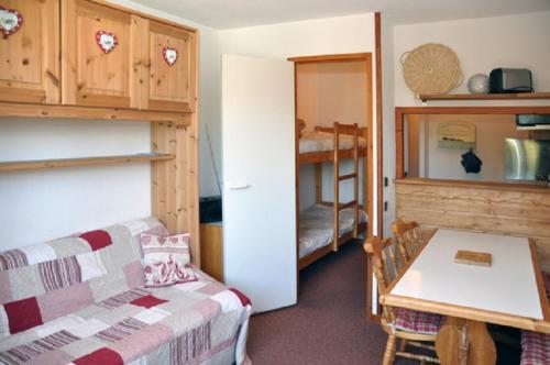 ein Wohnzimmer mit einem Bett und einem Tisch sowie ein Zimmer in der Unterkunft Les Melezets 1 in Valfréjus