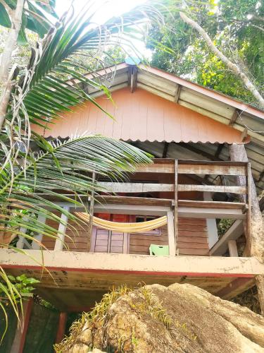 a house with a porch and a chair in front of it at Lae Tawan Bungalow in Koh Chang Ranong
