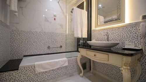 a bathroom with a sink and a mirror and a tub at Residence City Garden - Certificate of Excellence Top 10 BEST Five-Stars City Hotels for 2024 awarded by HTIF in Plovdiv