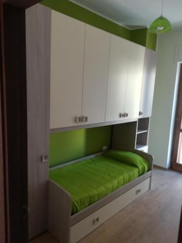 a bed in a room with green and white cabinets at Casa Giulia Vacanze in Baronissi