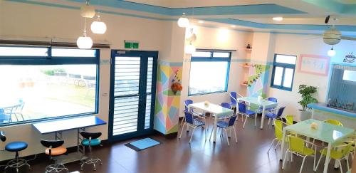 a classroom with tables and chairs and windows at B&B of Blueshine in Beigan