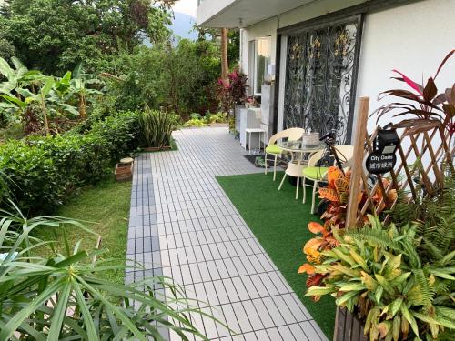 a garden path with a table and chairs and plants at City Oasis Guesthouse in Hong Kong