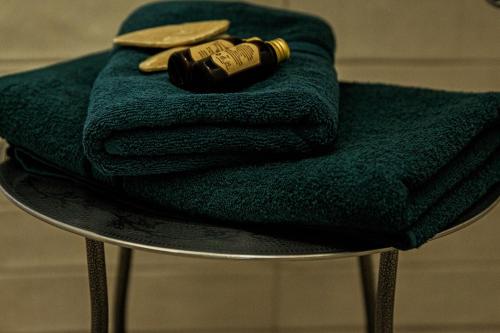a pile of towels and a bottle on a table at Centro apartamentai in Birštonas