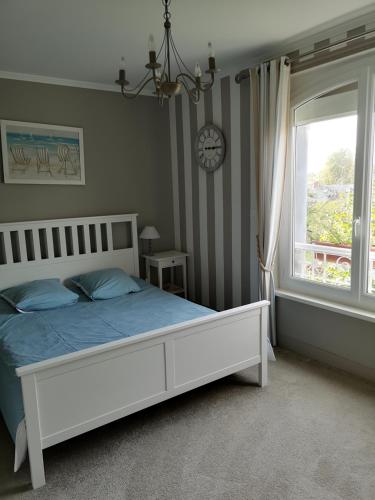 a bedroom with a white bed and a window at La Nouvelle Criqueboise in Criquebeuf-en-Caux
