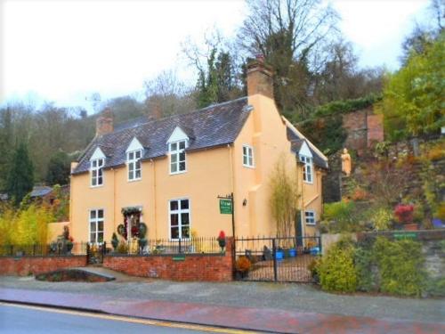 a large yellow house on the side of a street at Riverside Bed & Breakfast in Ironbridge