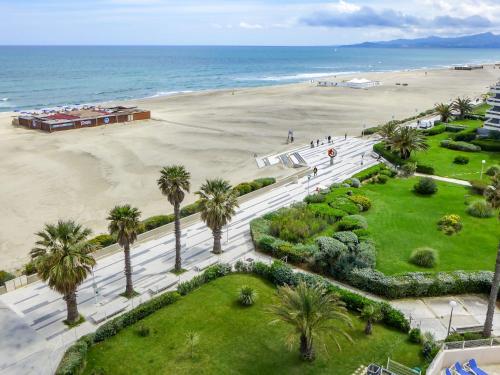 - une vue aérienne sur une plage bordée de palmiers dans l'établissement Apartment Le Beach-1 by Interhome, à Canet