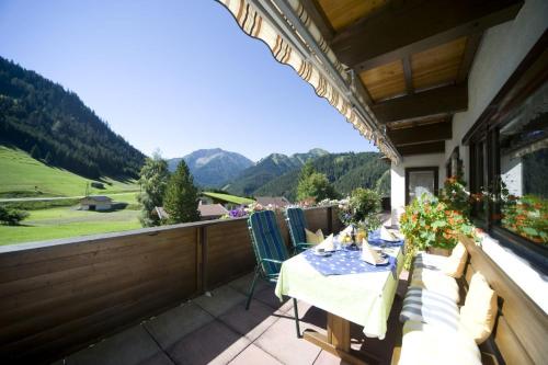 a patio with a table and chairs on a balcony at Gästehaus Bergland in Berwang