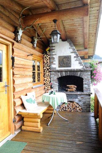 a patio with a fireplace and a table and a chair at Gästehaus Bergland in Berwang