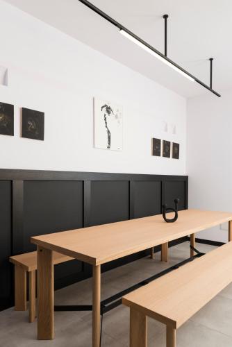 a table and benches in a room with paintings at BnBiz - Coworking Hotel in Fiorenzuola dʼArda