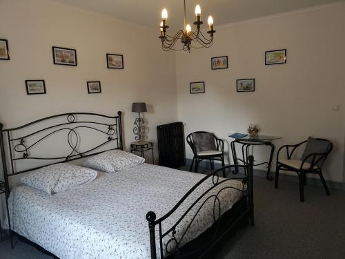 a bedroom with a bed and a table and chairs at La Nouvelle Criqueboise in Criquebeuf-en-Caux