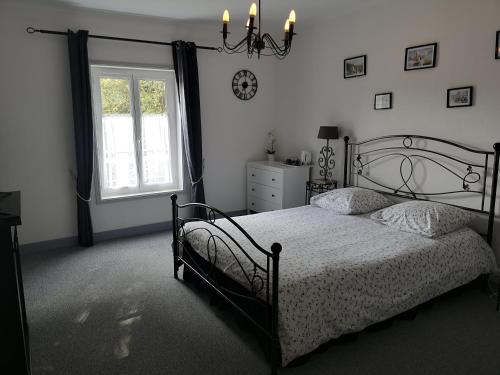 a bedroom with a bed and a window at La Nouvelle Criqueboise in Criquebeuf-en-Caux