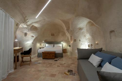 a bedroom with a bed and a couch and a table at Conche Luxury Retreat in Matera