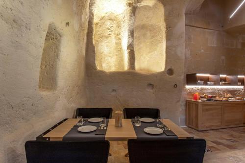 een eetkamer met een tafel en stoelen en een aanrecht bij Conche Luxury Retreat in Matera