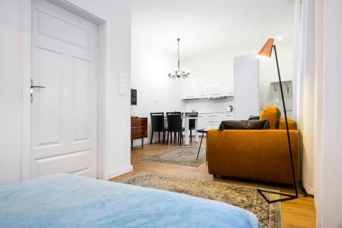 1 dormitorio blanco con sofá amarillo y cocina en Apartament Tenczyńska en Cracovia